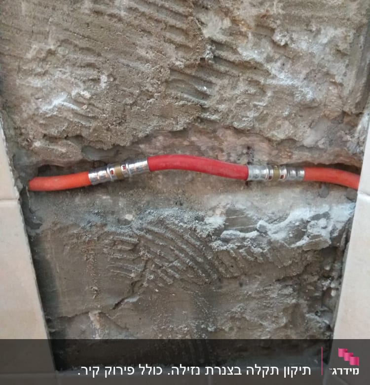 צינור אדום עם מחברים בקיר חשוף